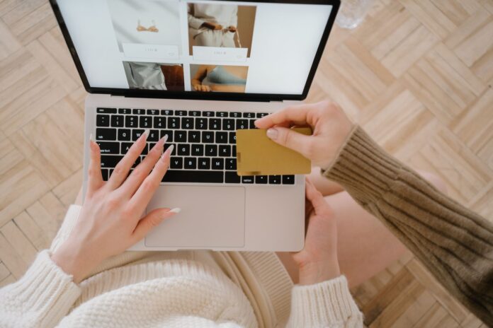 Person shopping online using a laptop and credit card, highlighting e-commerce convenience. Person shopping online using a laptop and credit card, highlighting e-commerce convenience.